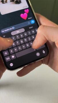 Texting I love you message in romantic mobile chat application with female thumbs. Woman hands typing romantic conversation or valentine text inside social network messenger. Modern