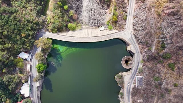Top down aerial stock footage of San Roque dam wall and spillway funnel in Cordoba