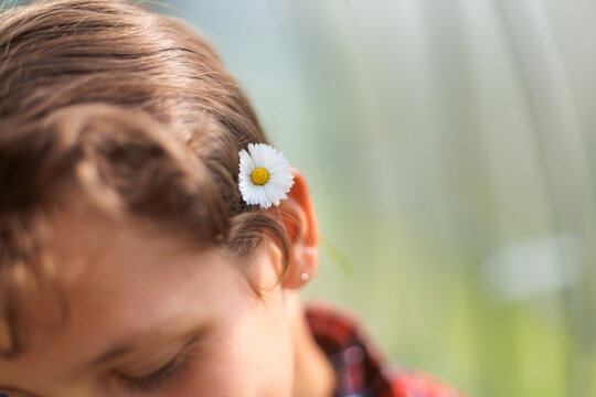 Cute Girl With Flower in Hair Smiling in a Sunny Garden