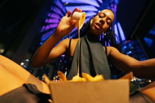 Pouring Cheese Sauce Over Fries