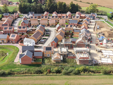 Drone view of a partially completed, very large housing development site in Britain. Both affordable and larger private family homes can be seen on this ever expanding building site.
