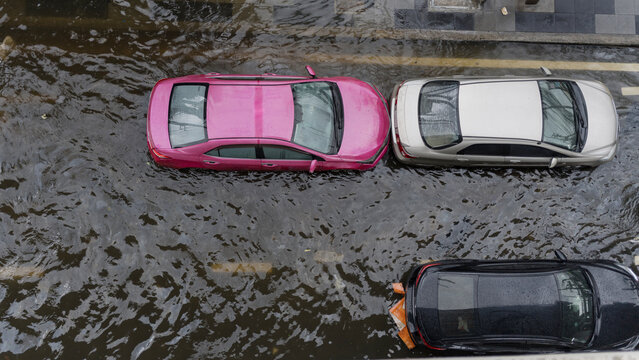 Aerial view of cars parked on a flooded city street after heavy rainfall during a storm event