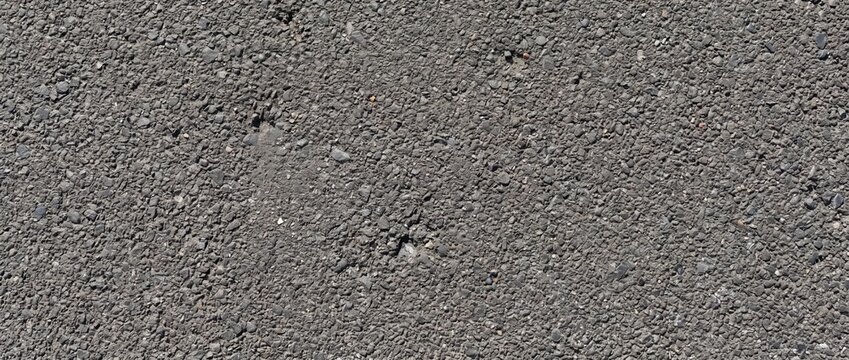 Asphalt pavement fine grain texture. Dark tarmac road surface background. Overhead highway gravel texture