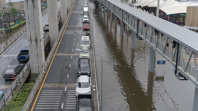 Elevated highway traffic and pedestrian walkway above flooded urban landscape in city environment