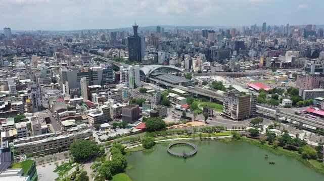 Aerial moving clip over the modern and futuristic architecture of Taichung   in downtown, with high rise towers standing among crowded buildings under blue sunny sky, in Taichung, Taiwan, Asia