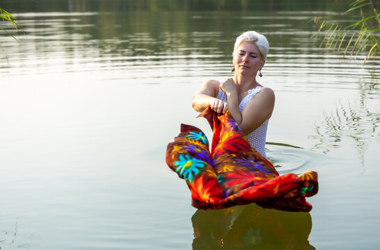 An older woman enjoys the calm water in evening light
