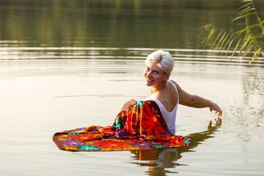 An older woman enjoys the calm water in evening light