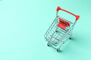 Small silver shopping cart on color background, top view © Sunlight