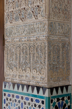 Carved Moorish plasterwork with Arabic calligraphy above tiles