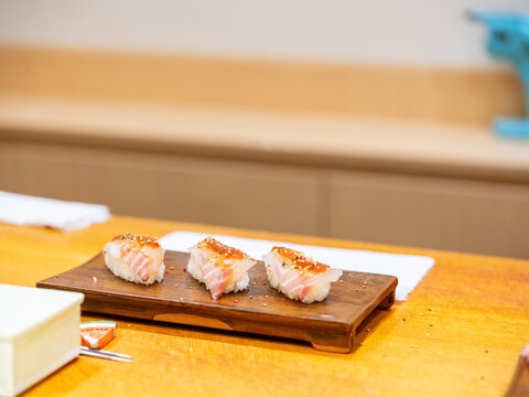 Sushi Chef Brushing Nikiri Sauce on Akami Tuna Nigiri Wooden Plate Chef Finishing Akami Nigiri Row