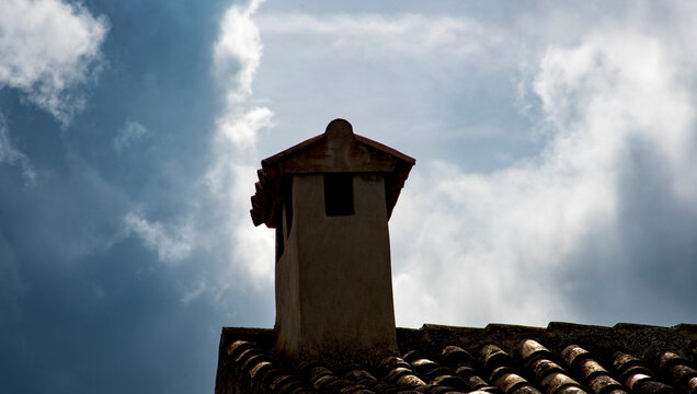 Tejado antiguo con una chimenea de obra con tejas &aacute;rabes.