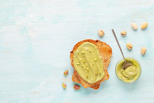 Grain bread toast with pistachio cream lying on plain toast. Top view