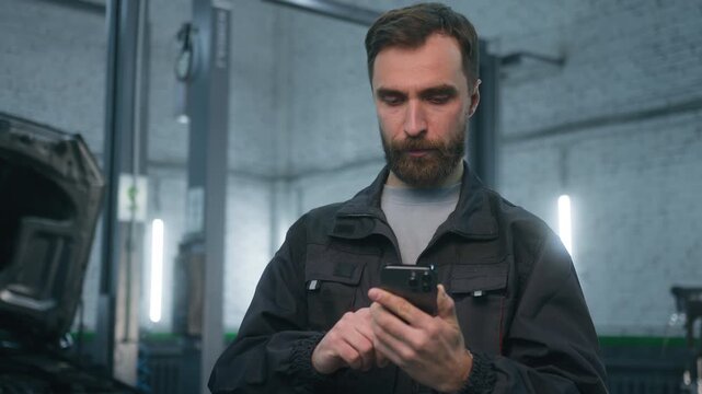 Angry Caucasian man auto mechanic shouting in mobile phone in car service station displeased male worker arguing about repair problem smartphone call annoyed technician client complaint inside garage