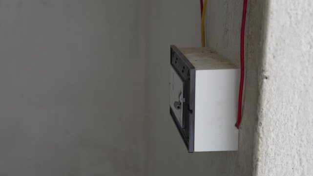 Electrician repairing wall switch board using a flexible screwdriver