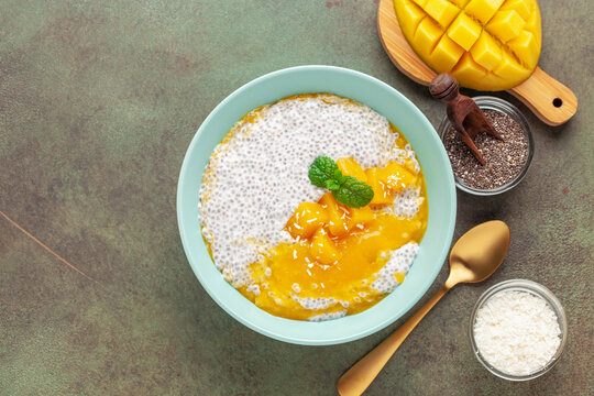 Chia seed pudding from coconut milk with mango puree and cubes  in bowl. Vegan  food. Clean eating concept