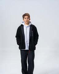 A young Asian man is wearing a black Sherpa fleece jacket, with a light gray hooded sweater underneath. © jeson