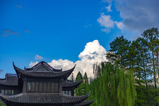 Traditional Chinese Pavilion with Lush Trees and Blue Sky