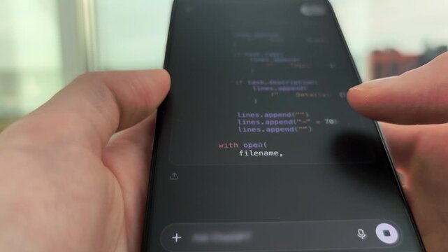 Programming code text lines scrolling on dark smartphone interface display screen panel. Female person monitoring automated script development generated by mobile large language model