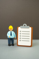 Official in a yellow hard hat with a paper clipboard. Inspections and tests. Audits and...