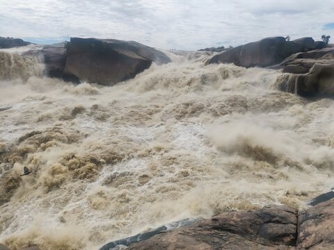 View of Augrabies Falls with powerful torrents of water cascading over rugged cliffs into the Orange River gorge, creating mist and spray in Augrabies, Northern Cape, South Africa.