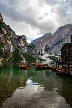 View of the wooden boathouse and rowing boats on the calm waters of the lake in the Dolomites, Rocca Pietore, Veneto, Italy.