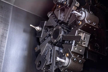 Precision CNC lathe turret with industrial cutting tools. This technical image is ideal for engineering, manufacturing, and heavy industry content. Selective focus. © ismailgazel