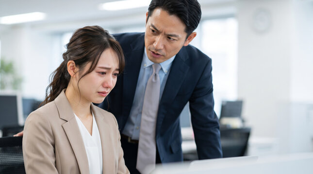 職場でのパワハラや叱責に耐え切れず泣いている女性社員と問い詰める上司