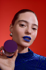 Fashionable woman with bold blue lipstick in a striking velvet bodysuit © LIGHTFIELD STUDIOS