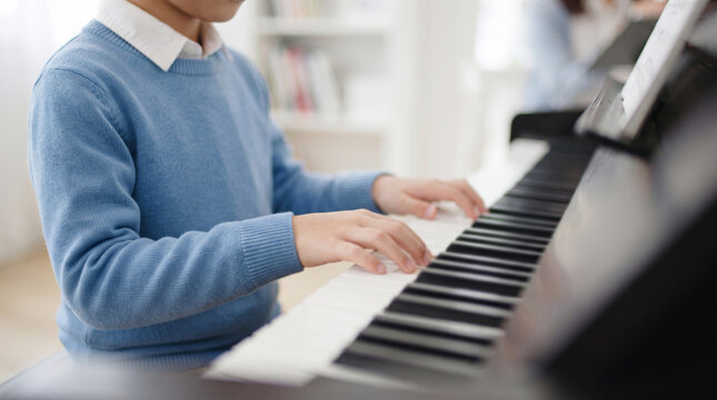 ピアノを練習する男の子の手元と鍵盤