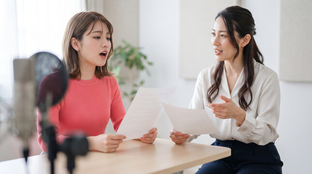 ボイストレーニングのレッスンを受ける女性と指導する講師