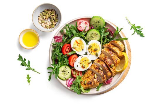 High protein lunch bowl with chicken, eggs and vegetable salad isolated