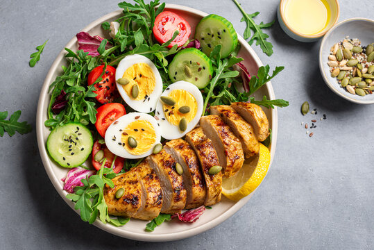 High protein lunch bowl with chicken, eggs and vegetable salad
