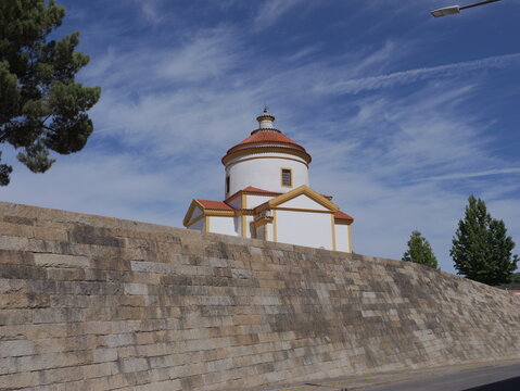 View of the historic Capela do Calvario with its white walls and terracotta dome rising above a massive stone fortification wall, Portalegre, Portalegre, Portugal.
