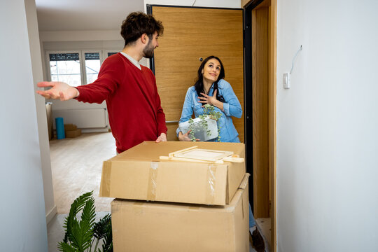 Man showing new apartment to happy woman holding decor box