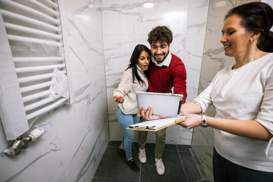 Surprised couple looking at digital tablet during real estate tour