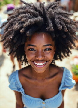 Close up portrait of happy smiling young african american woman with afro hairstyle outdoors.
