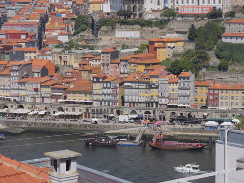 View of the historic Ribeira district with colorful buildings, traditional rabelo boats on the Douro River, and terracotta rooftops in Porto, Porto District, Portugal.