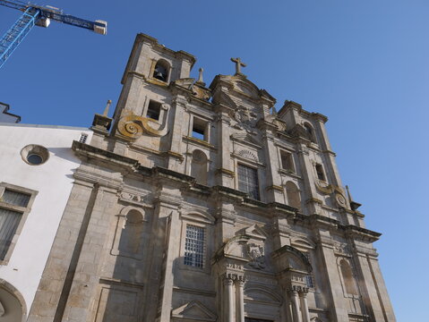 View of the ornate stone facade of the Igreja dos Congregados with its bell towers under a clear blue sky in Porto, Porto District, Portugal.