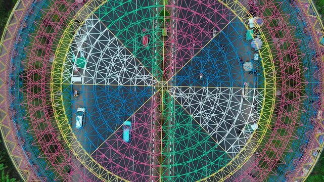 Aerial view of the vibrant circular geometric landmark featuring intricate patterns and bright colors situated above a busy road intersection in Mataram, West Nusa Tenggara, Indonesia.