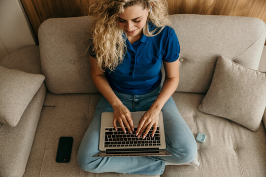 Young woman working remotely from home sofa