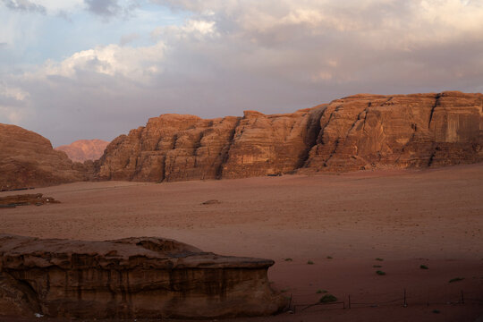 Massive sandstone mountains and red sand valleys in Wadi Rum desert at sunset