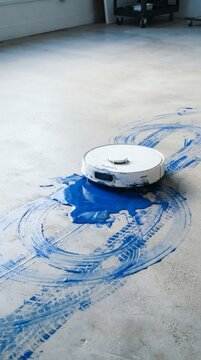 Robot vacuum cleaning blue paint spill on floor