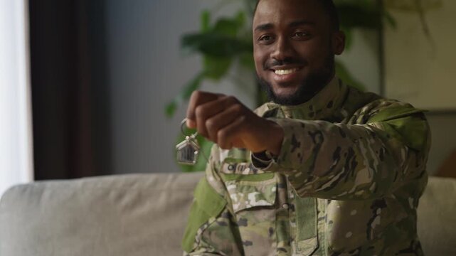 African American serviceman holds apartment key, military housing program