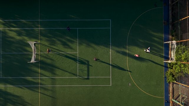 Aerial view of people playing soccer on a green court with white lines and goal posts in Bulgaria.