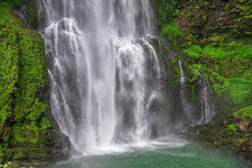 Lush Waterfall Cascading Over Rocky Cliff © PhamHong