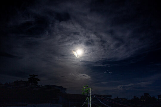 Full moon in the night sky with clouds