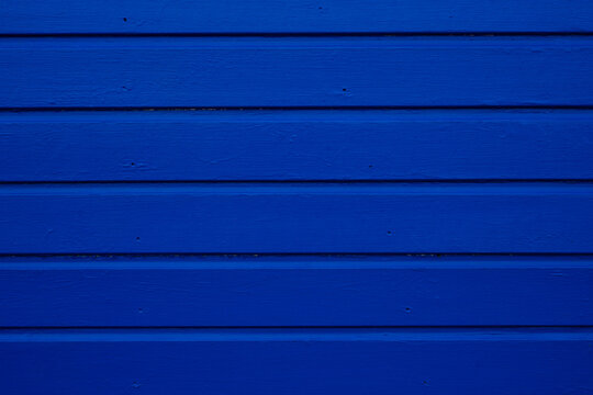 Vivid blue painted wooden boards with repeating horizontal lines