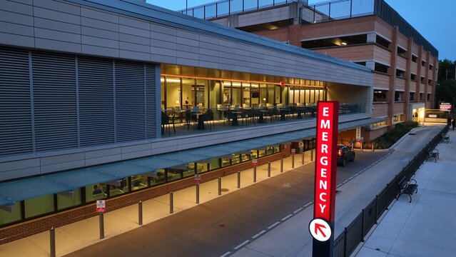 Neon Emergency sign at hospital in USA at night. Aerial establishing shot of emergency room and medical care building, Lancaster, Pennsylvania.