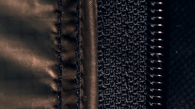 Close up view of a tent zipper moving in the wind at night