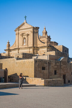 Female tourist with her back, photographing the facade of the Assumption Cathedral in the Citadel, Victoria - Gozo MALTA